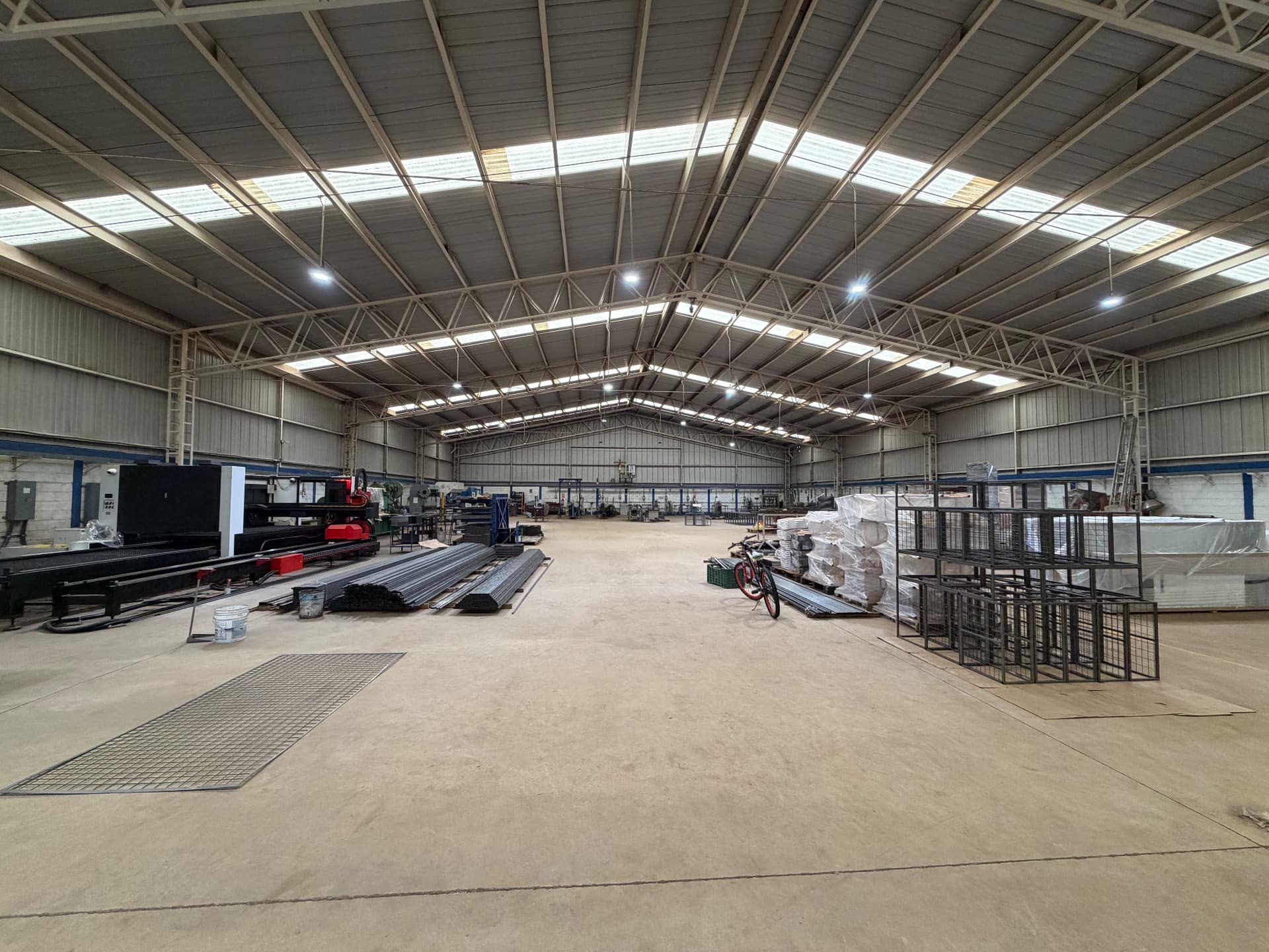 Vista panorámica del interior de la nave de ARANSA con láser CNC, perfil tubular y producto empacado