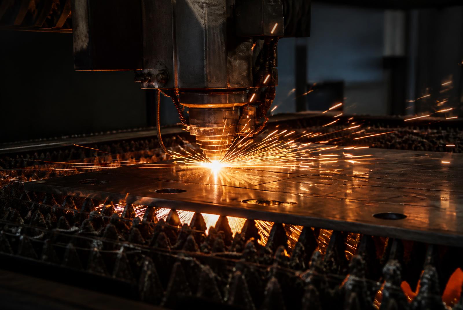 Cabezal de corte láser CNC seccionando placa de acero con chispas reales en planta de ARANSA