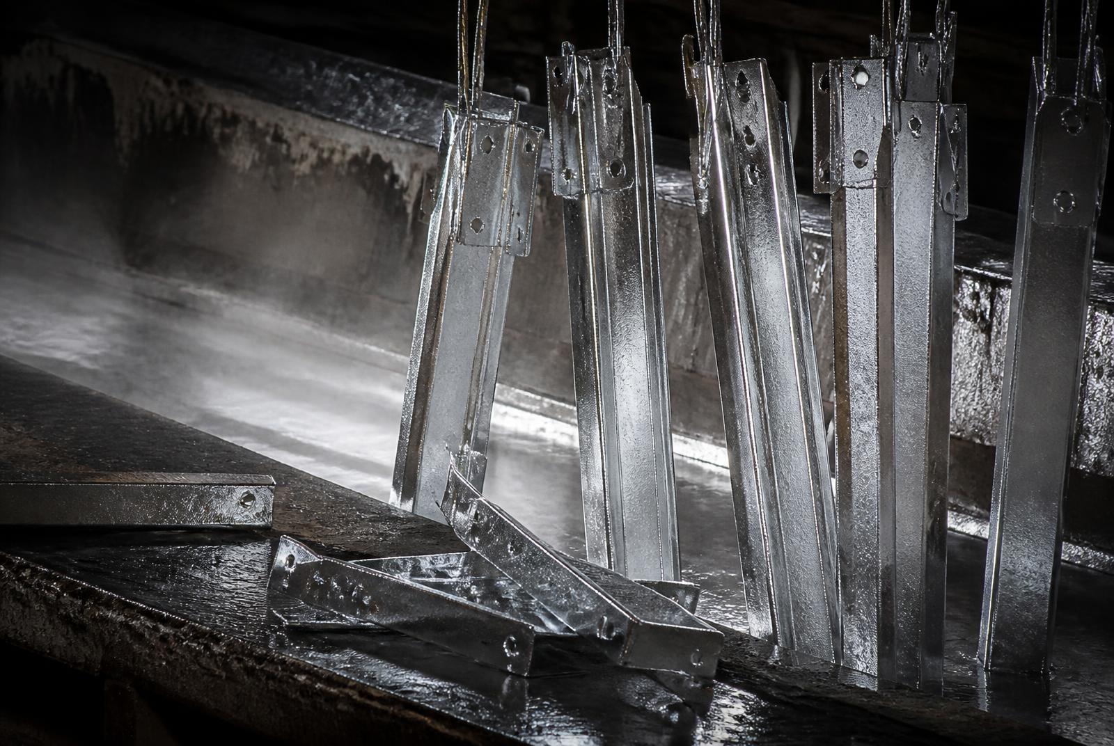 Piezas de acero recién galvanizadas saliendo del baño de zinc